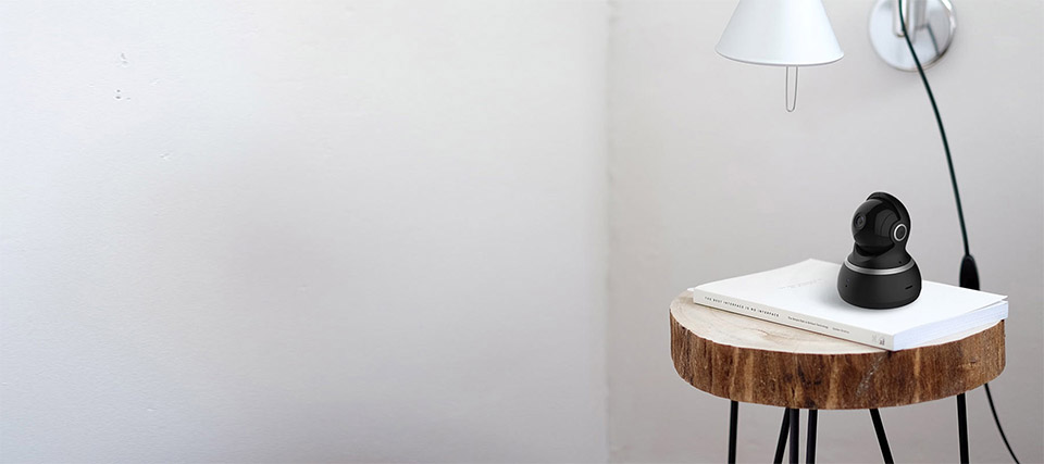 YI Dome Cámara IP en mesa de madera, habitación blanca